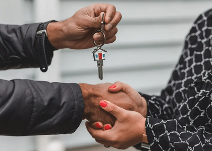 Een handover van sleutels tussen twee personen.