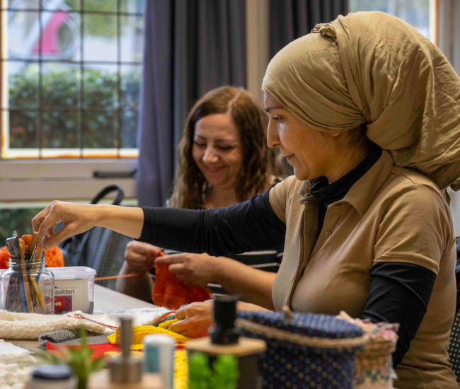 Vrouwen bezig met handwerk in een creatieve workshop.