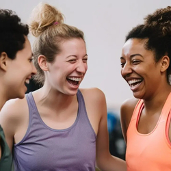 Drie lachende vrouwen in sportkleding, genietend van elkaars gezelschap.