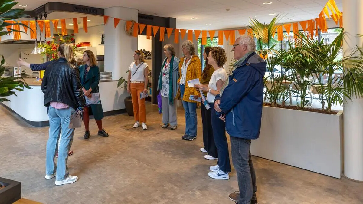 Een hand gebruikt een rekenmachine boven papieren documenten.