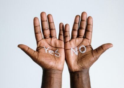 Handen met "Yes" en "NO" geschreven op de palmen.