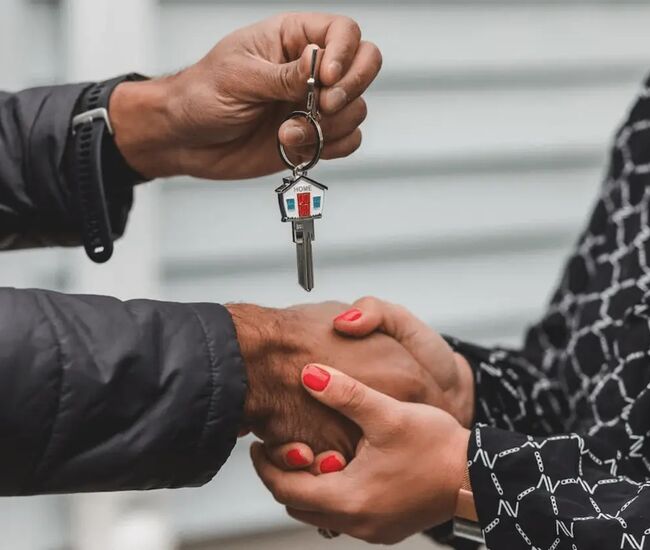 Een handover van sleutels tussen twee personen.