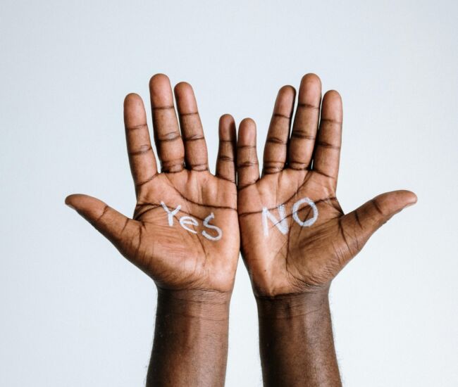 Handen met "Yes" en "NO" geschreven op de palmen.