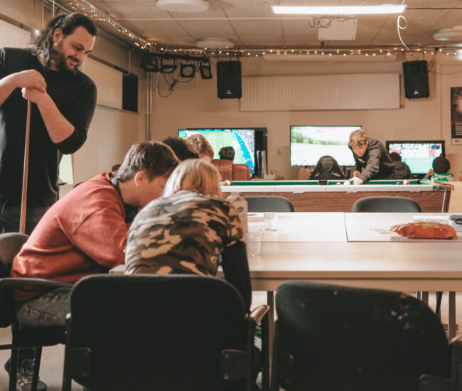 Groep jongeren speelt en socialiseert in een gezellige ruimte.