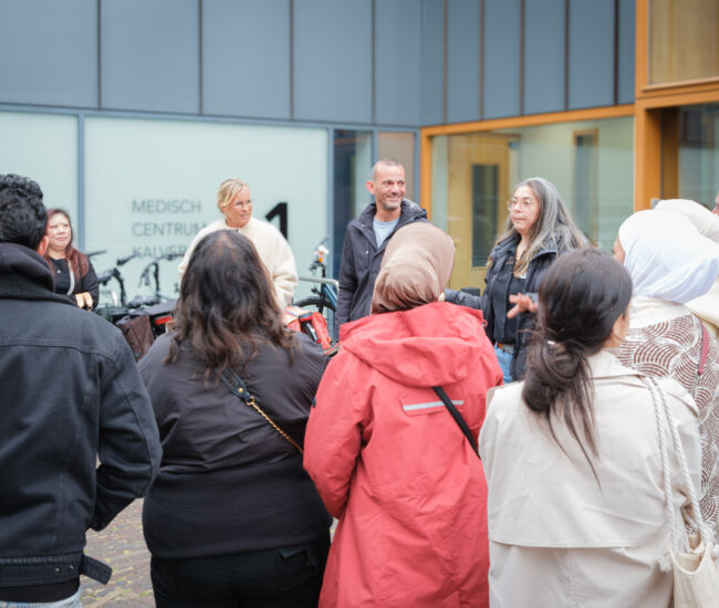 Groep mensen in gesprek bij een medisch centrum.