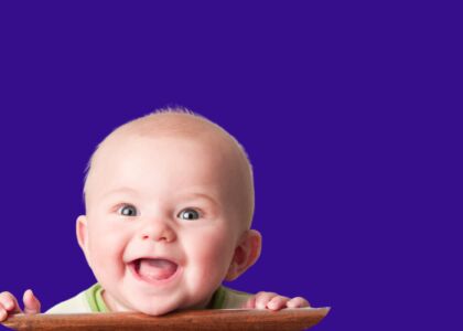 Een lachend babyhoofdje met een houten randje.