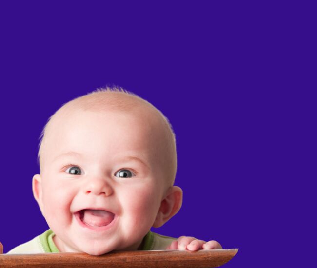 Een lachend babyhoofdje met een houten randje.