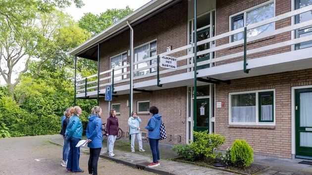 Groep mensen voor een gebouw met de naam 'wijkpost Het Bastion'.