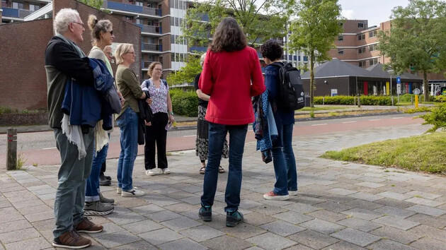 Groep mensen staat in een cirkel en praat buiten.